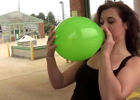 Fifi foxx blows and pops balloons outdoors